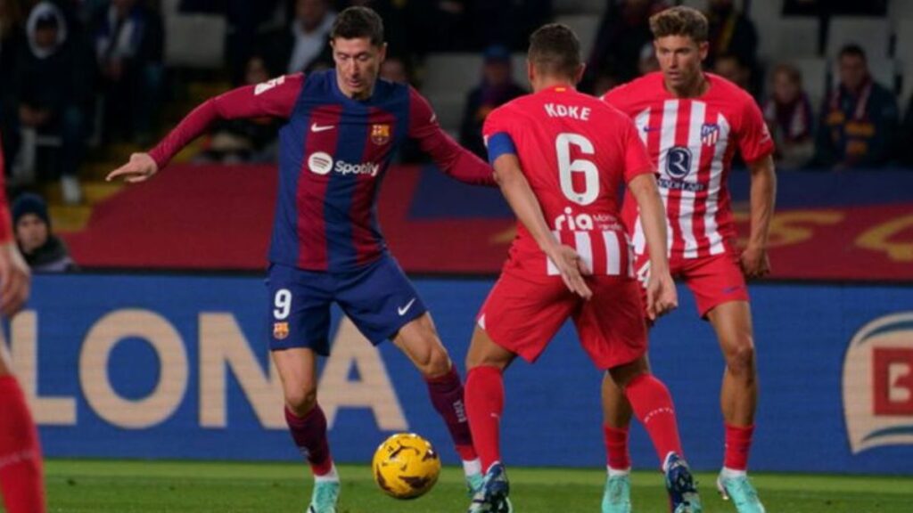 Lewandowski controlando un balón delante de Koke en 2023