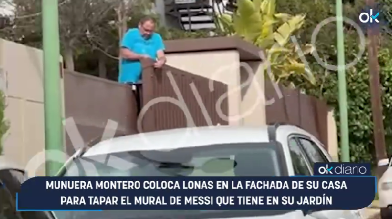 Un operario tapando el mural de Leo Messi de Munuera Montero